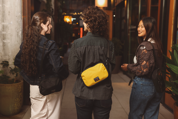 People wearing the Big Bantam on their shoulders and bag walking down the street